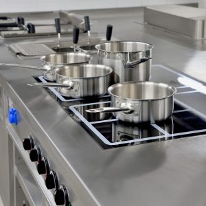 Stainless steel pots built on the stove in the restaurant kitchen